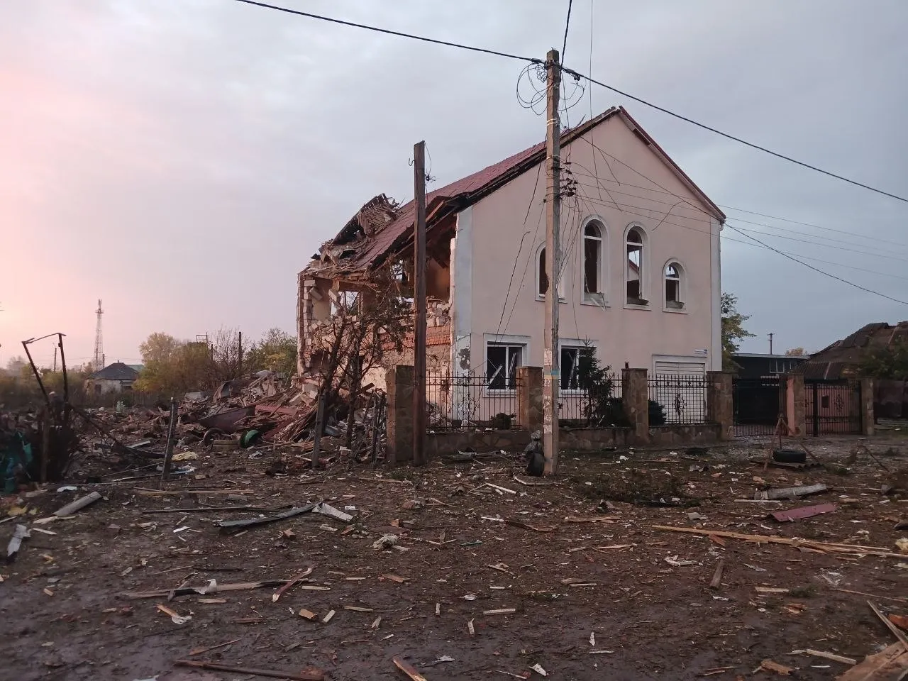 Двоповерхова будівля з обваленою частиною даху і стіни, навколо розкидані уламки деревини