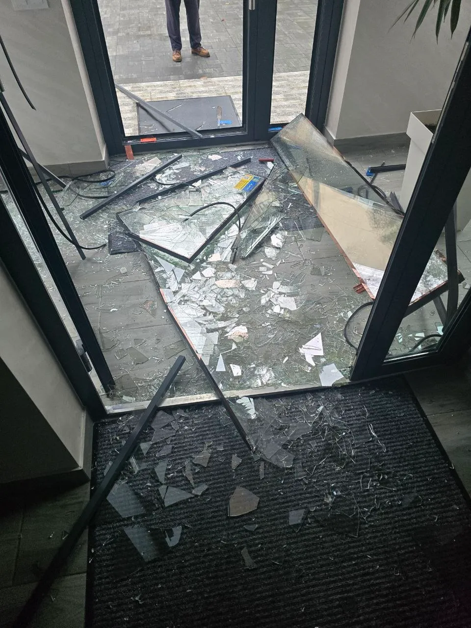 Розбите скло вибитих дверей встелило підлогу вестибюля будівлі