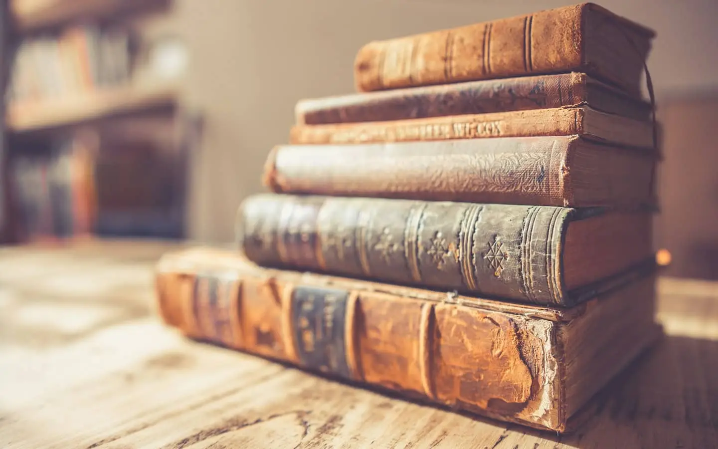 Стос старих книг з потертими шкіряними палітурками на столі