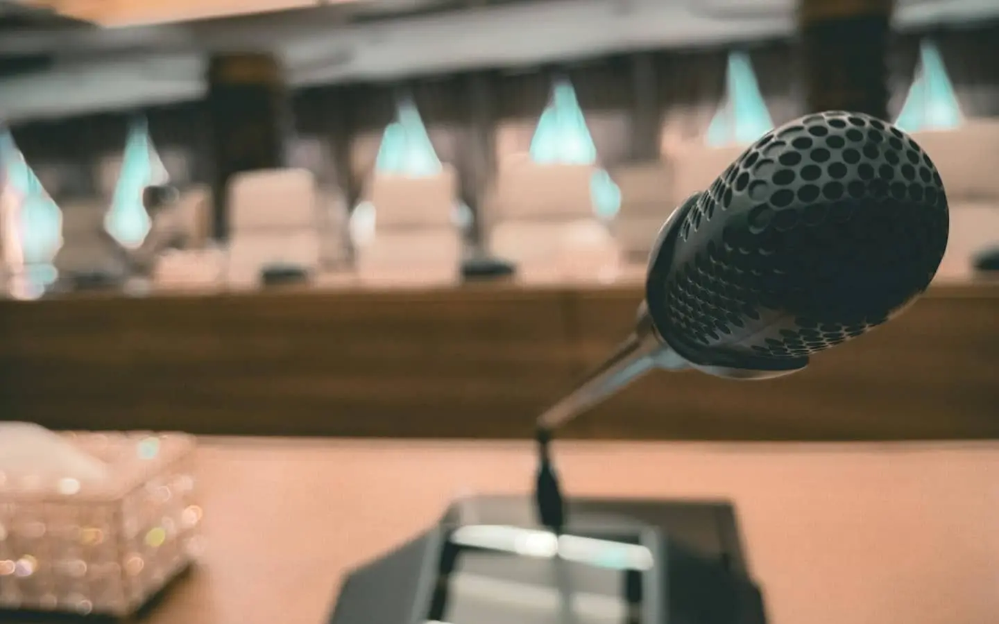 Мікрофон крупним планом на тлі залу засідань